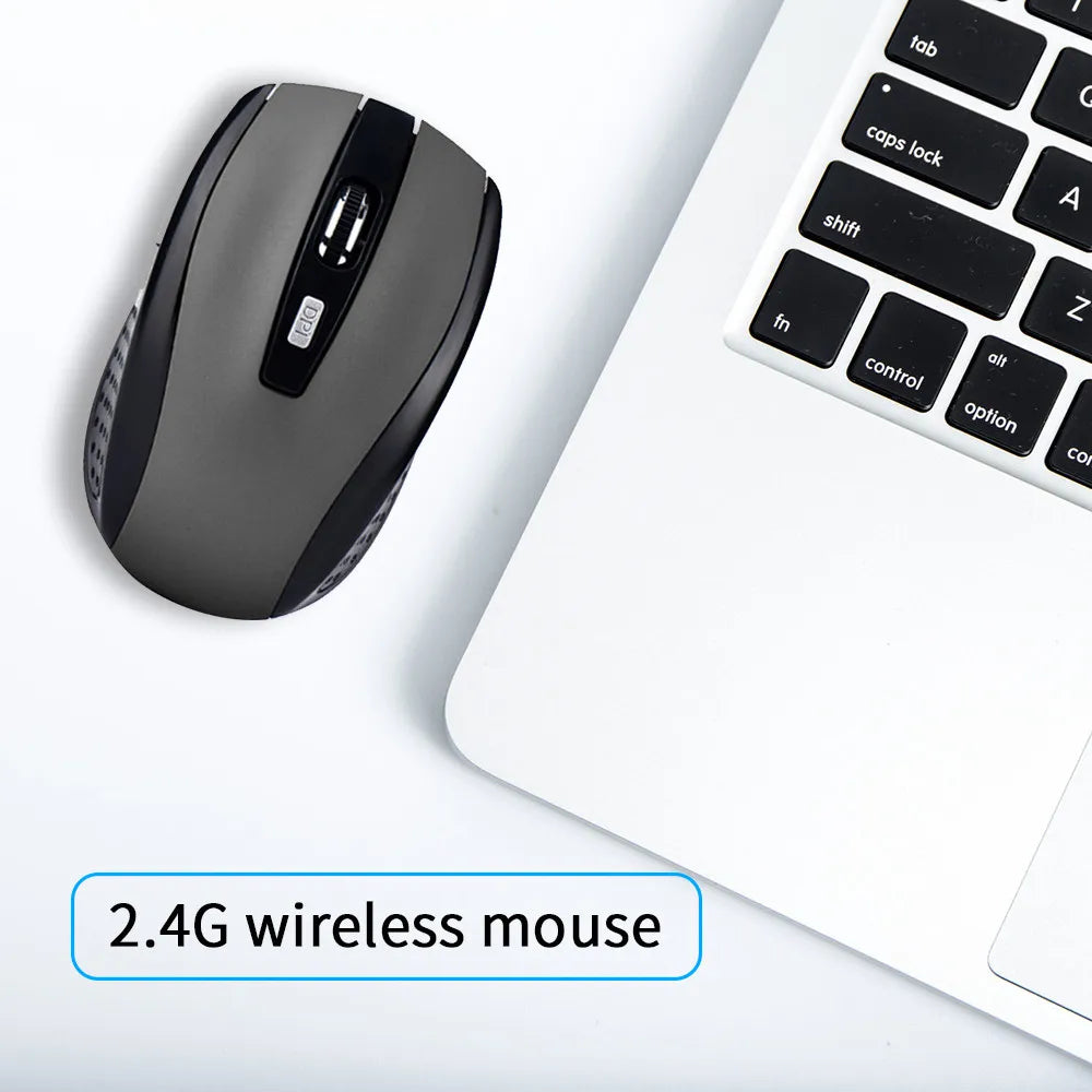 Black 2.4G wireless mouse next to a laptop keyboard on a white background